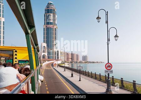 30 novembre 2025, Doha, Qatar: Turisti che si godono un tour in autobus lungo il lungomare di Pearl, ammirando lo skyline e l'architettura moderna Foto Stock