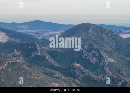Vista panoramica delle lussureggianti montagne verdi e delle profonde valli della Catalogna. vista ad alta quota che mostra picchi lontani e architetture rurali remote Foto Stock