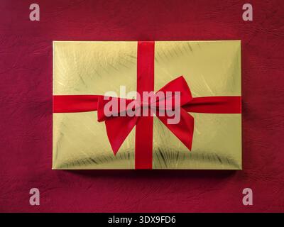 Scatola di cioccolato dorato con il nastro rosso sparato dall'alto Foto Stock