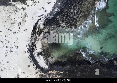 Vista aerea del forte contrasto tra la spiaggia di sabbia bianca e le scure rocce vulcaniche che incontrano l'oceano turchese, Órzola, Isole Canarie, Spagna Foto Stock