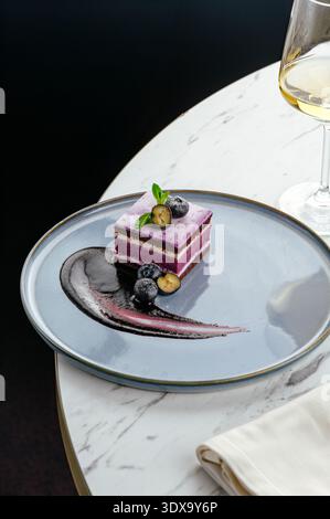 dessert ai mirtilli su un piatto con frutti di bosco e decorazioni Foto Stock