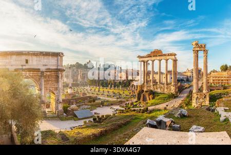 Vista panoramica del foro Romano con l'Arco di Settimio Severo e le colonne del Tempio di Saturno all'alba nella città di Roma, in Italia. Antiche rovine del tempio Foto Stock