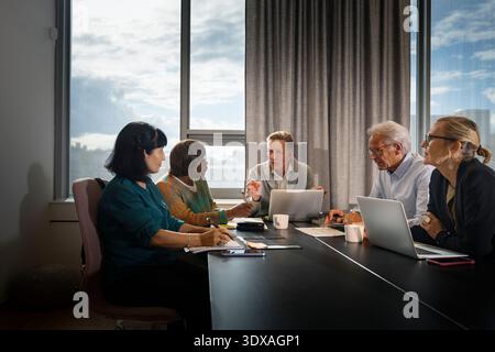 Il senior management discute le strategie aziendali durante la riunione Foto Stock