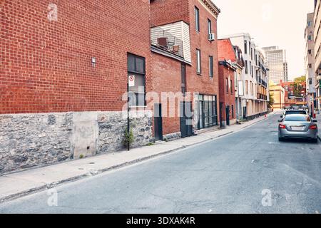 Camminando lungo una strada lunga e stretta nella città di Montreal, vecchi edifici residenziali in mattoni che costeggiano la strada, mostrando l'architettura urbana Foto Stock