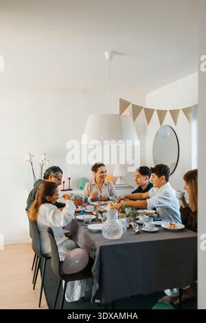 Pranzo in famiglia seduto intorno al tavolo da pranzo a casa Foto Stock