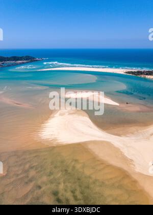Vista aerea dell'estuario sabbioso dove il fiume incontra il vasto oceano, contrastando la sabbia dorata con il profondo blu del mare, Nambucca Heads, ne Foto Stock
