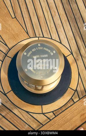 Verricello in ottone sul ponte delle barche in teak con dettagli in metallo nautico e inserti decorativi Foto Stock
