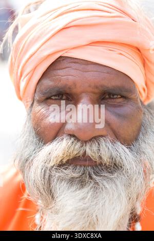 Ritratto ravvicinato di un Sadhu indù che indossa un turbante arancione nel complesso del tempio Pashupatinath, Kathmandu, Nepal. Foto Stock