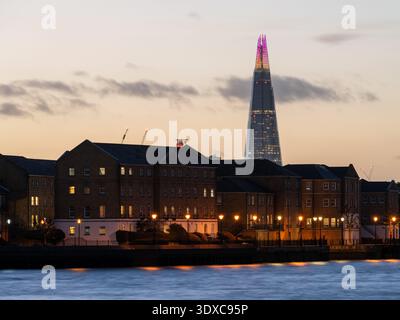 Il sole tramonta dietro il grattacielo Shard e gli appartamenti che costeggiano il fiume Tamigi a Rotherhithe, Londra. Foto Stock