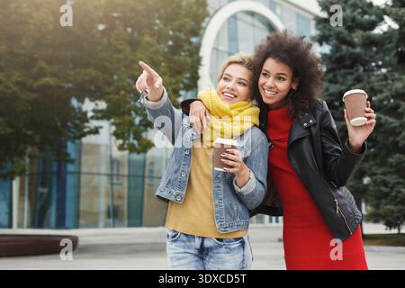 Gli amici si godono un drink e condividono un momento durante una giornata di sole in un ambiente cittadino Foto Stock