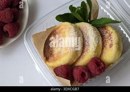 Una deliziosa colazione al sacco con soffici pancakeswith raspberries Syrniki Foto Stock