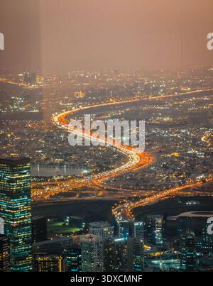 11 30 2025 - Dubai, Emirati Arabi Uniti. C'è un ingorgo di traffico a Dubai di notte. Vista aerea dei droni della lunghezza di chilometri delle luci per auto Foto Stock