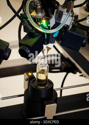 Produzione di profumi. Profumi diversi in bottiglia. Linea di produzione robotizzata di profumi con erogazione automatica di fragranze Foto Stock
