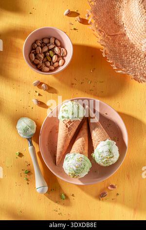 Gelato al pistacchio freddo e delizioso in un cono di cialde. Gelato a base di panna e pistacchi. Foto Stock
