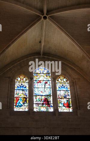 Vetrate colorate all'interno della Cattedrale di Santa Maria di Burgos luglio 2024, ricche sfumature gotiche che gettano ombre sulle pareti di pietra Foto Stock