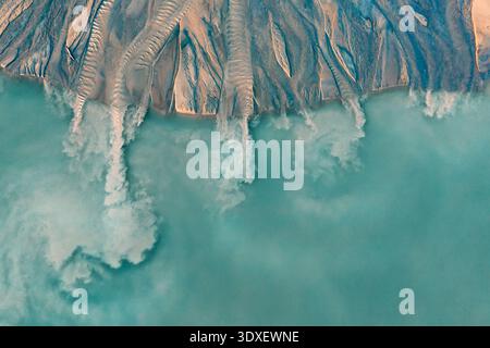 Vista aerea di ruscelli intrecciati che cadono in un fiume turchese lattiginoso, le rive sabbiose contrastano nettamente con la tonalità eterea dell'acqua, Siemiatycze, Foto Stock