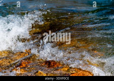 Le onde si infrangono sulle rocce del porto di Torri del Benaco vicino al Lago di Garda Verona Veneto Italia Foto Stock