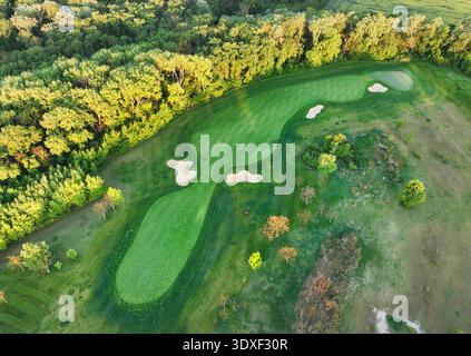 Vista aerea del tramonto sul campo da golf con alberi e laghi dai colori primaverili Foto Stock