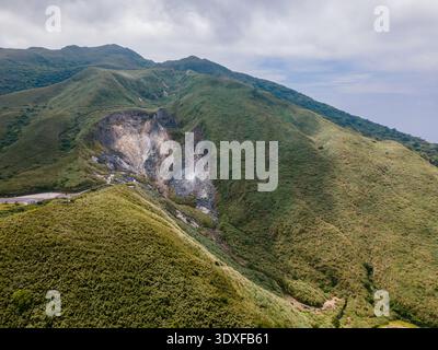 Vista droni delle fumarole fumanti e delle prese d'aria geotermiche nell'area ricreativa di Xiaoyoukeng nel Parco Nazionale di Yangmingshan, Taiwan, con depositi di zolfo Foto Stock