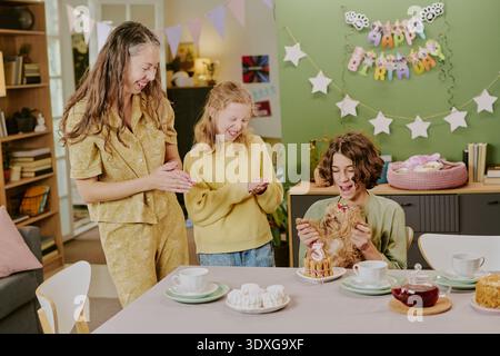 Donna caucasica e due bambini festeggiano il compleanno con il cane piccolo al chiuso Foto Stock