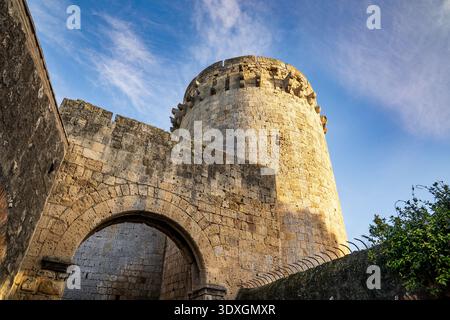 Una suggestiva vista a basso angolo di porta di Castello a Tarquinia, caratterizzata dall'imponente torre circolare di avvistamento del XV secolo. L'immagine evidenzia l'enorme Foto Stock