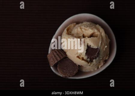 Una vista dall'alto verso il basso di una singola paletta di gelato cremoso al burro di arachidi con pezzi di caramelle visibili al cioccolato e al burro di noci Foto Stock
