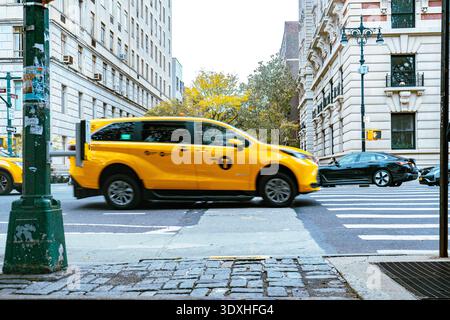 New York, USA - 25 ottobre 2025: Traffico che passa su una strada cittadina. Scena di Manhattan Street a New York. Effetto di sfocatura del movimento. Vita urbana Foto Stock