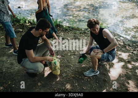 Gli amici lungo il fiume possono godersi un incontro informale, condividendo spuntini e bevande all'aperto Foto Stock