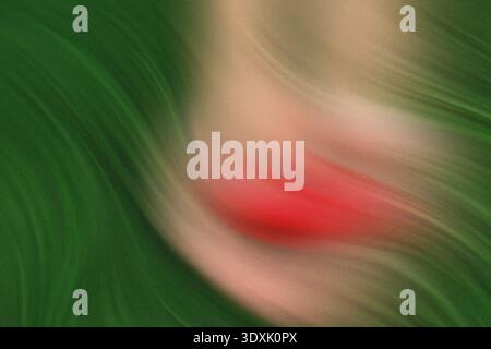 Primo piano sfocato di una persona che tiene una piccola palla rossa su uno sfondo verde in un ambiente all'aperto Foto Stock