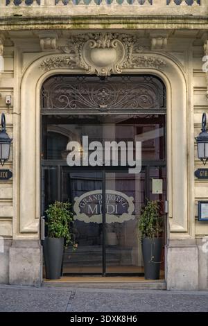 Grand Hôtel du Midi, Grand Hotel du Midi. Storica facciata del XIX secolo con porta ad arco, muratura in pietra e ferro battuto a Montp Foto Stock