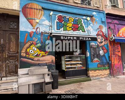 Super Pizza, negozio da asporto a Cours Julien, Marsiglia, Francia, che presenta colorate opere d'arte di graffiti di una fetta di pizza a cartoni animati e Mario Characte di Nintendo Foto Stock