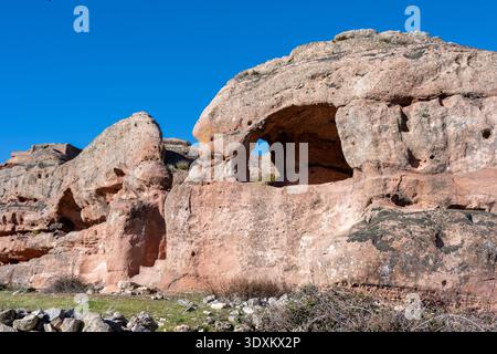 Formazione di pietra arenaria erosa con una finestra naturale e forme arrotondate di scogliera nel sito archeologico di Tiermes a Soria, Spagna. Foto Stock