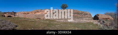 Vista panoramica delle scogliere di arenaria a strati e dell'altopiano del sito archeologico di Tiermes a Soria, Castiglia e León, in Spagna, in una giornata di sole. Foto Stock