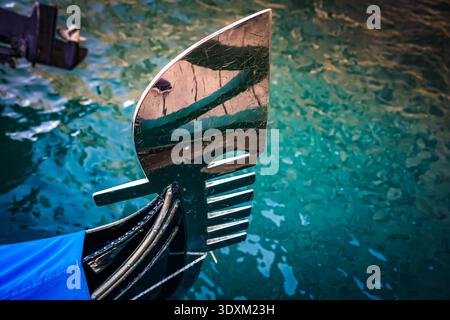 Prima vista dell'ornamento della prua ferro di prua di una gondola sull'acqua turchese, Venezia, Italia Foto Stock