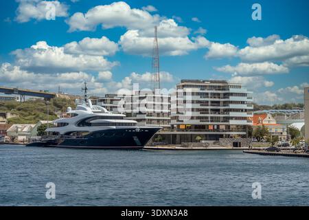Moderno condominio fronte mare, lussuoso appartamento per vacanze con grande yacht ormeggiato nel porto di Willemstad Curacao Foto Stock