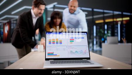 Analisti finanziari e consulenti di marketing esaminano i grafici di analisi dei dati durante il lavoro di squadra. In un ufficio Foto Stock