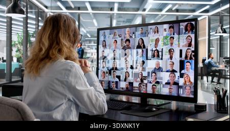Donna d'affari che conduce una conferenza virtuale in un ambiente moderno Foto Stock
