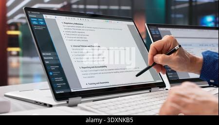 Avvocato che esamina il documento di conformità sul laptop, garantendo la riservatezza del paziente. Foto Stock