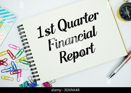 Messaggio di testo del rapporto finanziario del 1° trimestre scritto su blocco note con piano di cancelleria su sfondo bianco Foto Stock