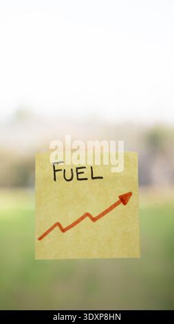 Nota adesiva gialla che mostra il carburante e una freccia di tendenza verso l'alto Foto Stock