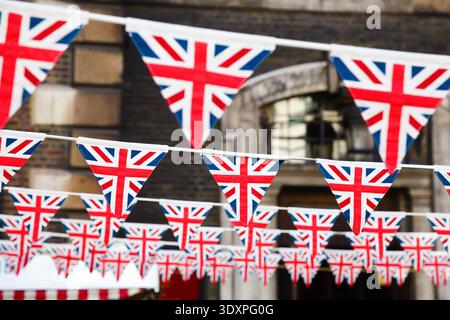 Union Jack flag triangolare di bunting appesi in una strada, una festosa decorazioni in Londra England Regno Unito Foto Stock