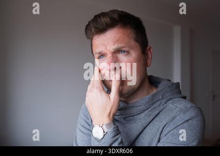 un uomo in difficoltà di mezza età che si sente sopraffatto e bloccato in una situazione difficile Foto Stock