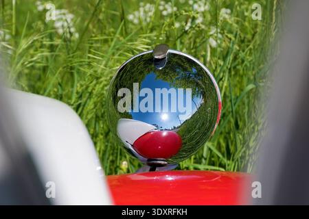 Faro di una Citroen 2CV riflessa sull'erba verde in estate, foto dettagliata, primo piano Foto Stock