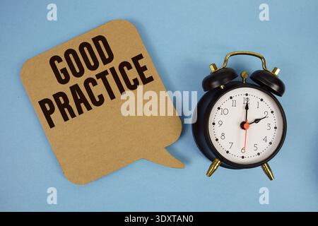Testo di buona pratica con sveglia su sfondo blu Foto Stock