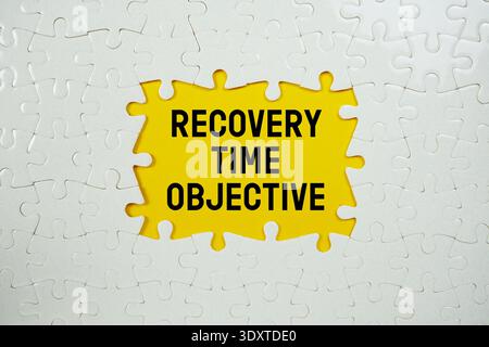 Puzzle con un pezzo mancante con "obiettivo tempo di recupero" su sfondo giallo Foto Stock