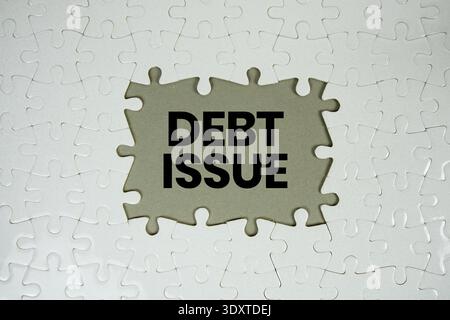 Puzzle con un pezzo mancante con "debito" su sfondo grigio Foto Stock