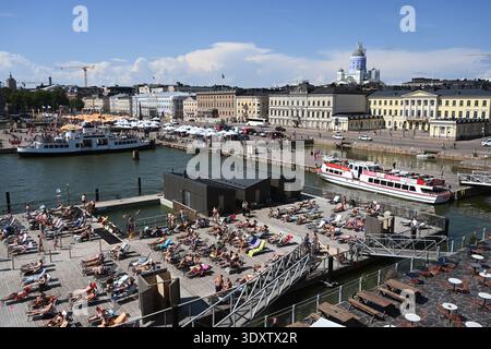 Helsinki, Finlandia - 25 luglio 2024: Un popolo si riposa vicino al porto di Helsinki in estate giorno di sole. Foto Stock