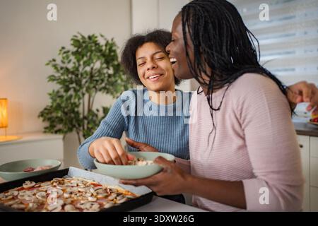 Madre e figlia fanno la pizza insieme divertendosi Foto Stock