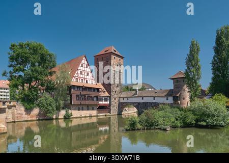 Vista della torre dell'acqua, del ponte Henkersteg e della torre Henkerturm nella città vecchia di Norimberga sul fiume Pegnitz in Germania Foto Stock