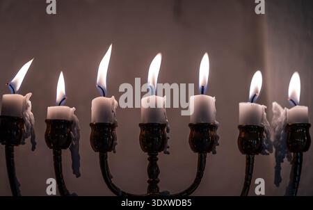 Menorah tradizionale con candele bianche bruciate Foto Stock